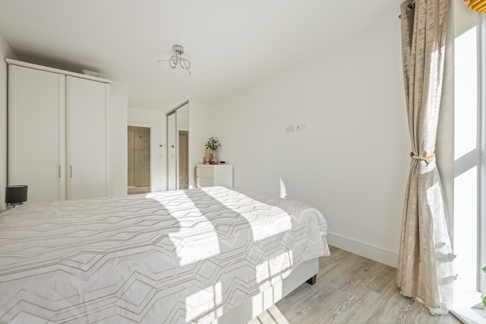 Master bedroom with king-size bed, fitted wardrobes and en-suite access